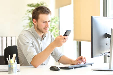 Serious office worker checking online smart phone contentの写真素材