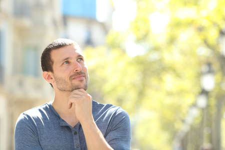 Serious adult man thinking looking at side standing in the street with copy spaceの写真素材