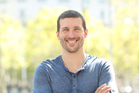 Front view portrait of a happy adult man posing looking at camera in the streetの写真素材