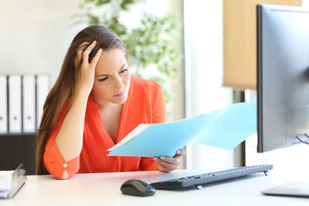 Worried busnesswoman complaining after discover mistake on document at officeの写真素材