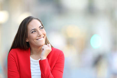 Candid woman thinking looking at side in the street with copy spaceの写真素材