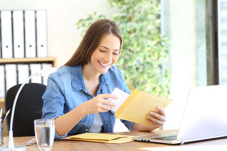 Happy entrepreneur putting document in an envelope  working at officeの写真素材