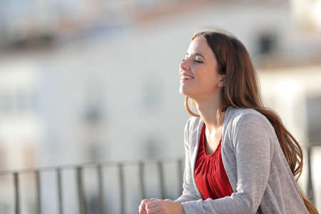 Happy girl breathing fresh air in a balcony a sunny dayの写真素材