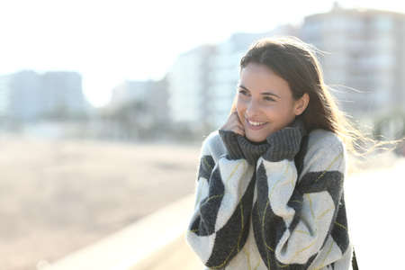 Happy girl wearing sweater heating in winter standing in the streetの写真素材