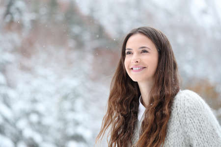 Candid beautiful teen watching snow in the mountain in winterの写真素材