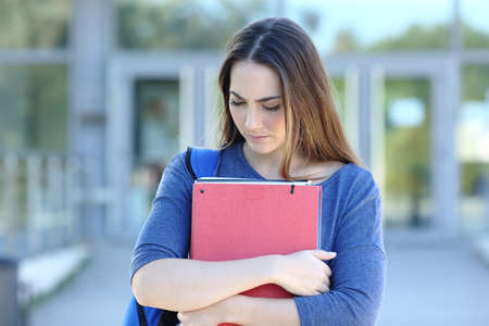 Sad student walking looking down complaining in an university campusの写真素材