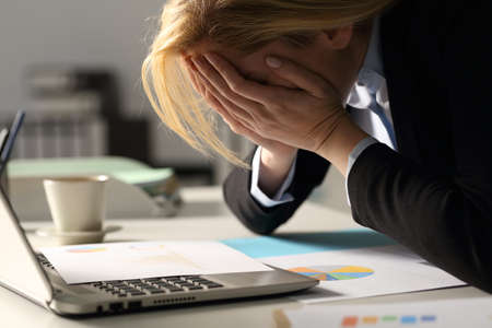 Close up of sad executive woman complaining over bad results at night in the office