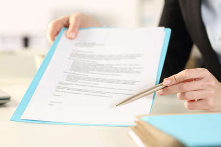 Close up of business woman hands showing and pointing contract signature space in the officeの写真素材