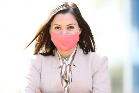 Front view portrait of a happy woman wearing protective mask avoiding coronavirus contagion or pollution posingの写真素材