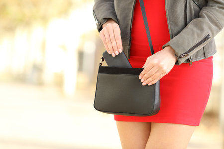 Close up of fashion woman hands taking off smart phone from purse in the streetの写真素材