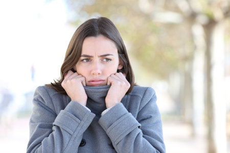 Front view portrait of an angry woman getting cold in winter in the streetの写真素材