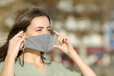 Woman walking putting mask due covid in the streetの写真素材