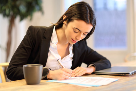 Happy businesswoman signing paper form working at officeの写真素材
