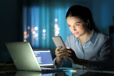Entepreneur working with multiple devices late hours in the night at officeの写真素材