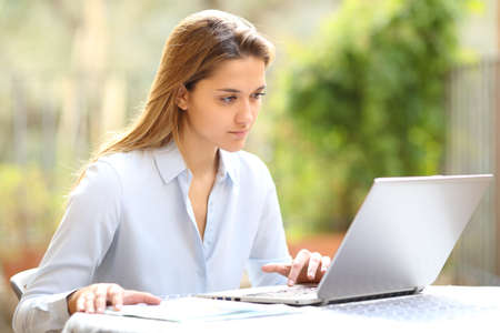 Concentrated entrepreneur working with laptop in a garden at homeの写真素材