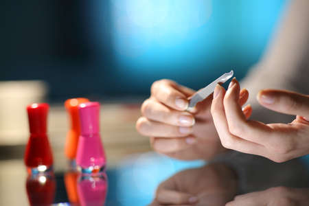 Close up of a woman hands filing nails ready to manicure in the night at homeの写真素材