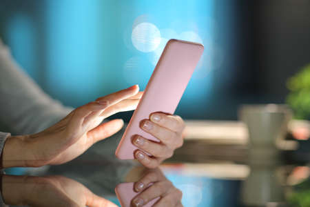 Close up of a woman hand using smart phone in the night at homeの写真素材