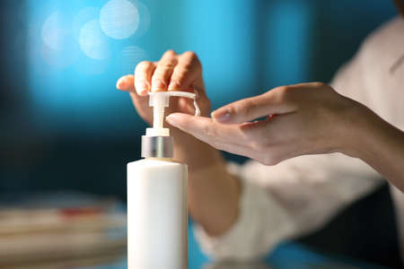 Close up of a woman hands applying moisturizer cream in the night at homeの写真素材