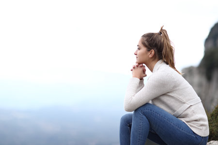Side view portrait of a happy woman contemplating views in the mountainの写真素材