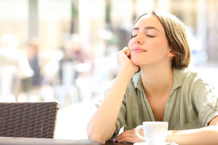 Happy woman relaxing with closed eyes sitting in a coffee shopの写真素材