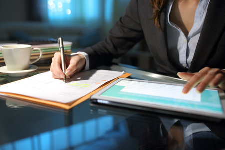 Close up ofn entrepreneur hands comparing paper form with tablet online content at homeofficeの写真素材