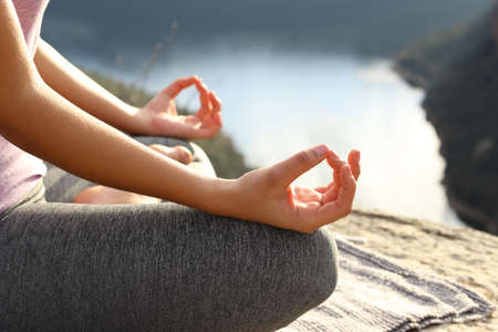 Close up of a woman hands doing yoga exercise in the mountainの写真素材
