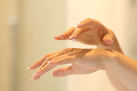 Close up of a woman hands applying moisturizer cream in the bathroomの写真素材