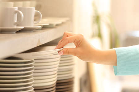 Close up of a woman hand holding a plate in the kitchen