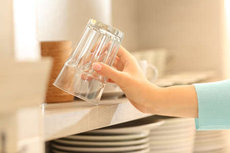 Close up of a woman hand catching a glass in the kitchenの写真素材