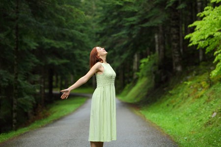 Happy woman smiling breathing fresh air in the mountain roadの写真素材