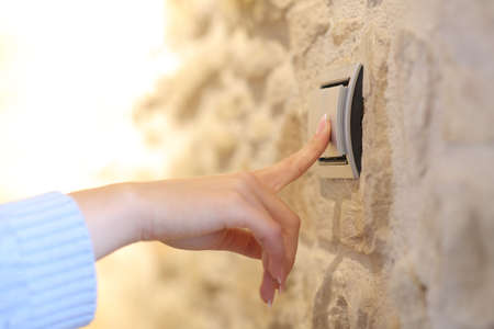 Close up of a woman hand turning on the light at homeの写真素材
