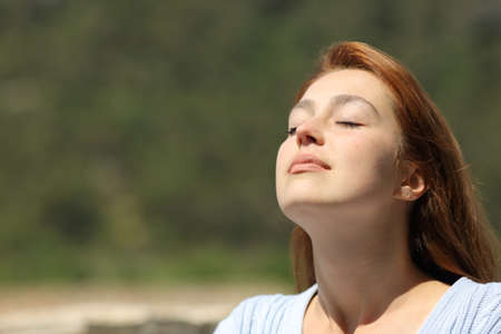 Woman relaxing breathing fresh air a sunny day in natureの写真素材