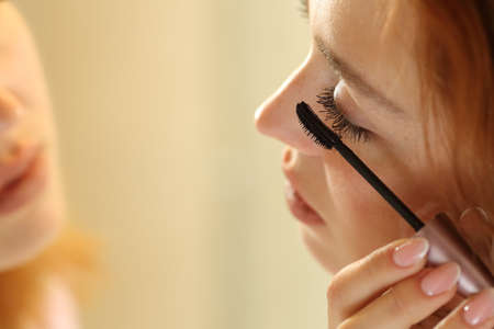 Close up of a woman painting eyelashes in the bathroomの写真素材