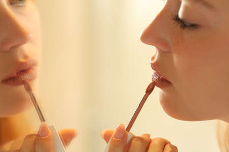 Close up of a woman painting lips looking at mirrorの写真素材