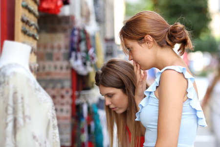 Two doubtful women wondering what to buy in a store in the streetの写真素材