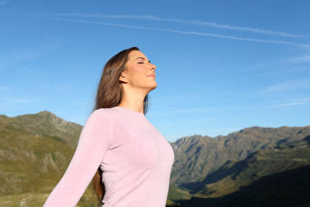 Casual woman breathing fresh air in a high mountain a sunny dayの写真素材