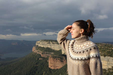 Relaxed woman in winter looking away in natureの写真素材