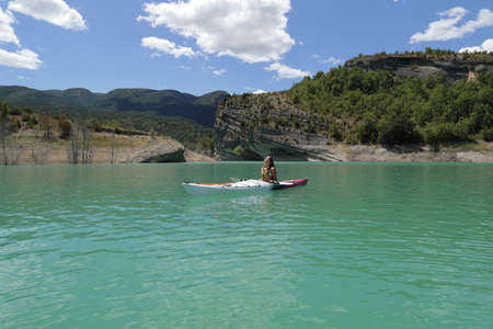Single woman relaxing breathing fresh air in a kayak in a beautiful lagoonの写真素材