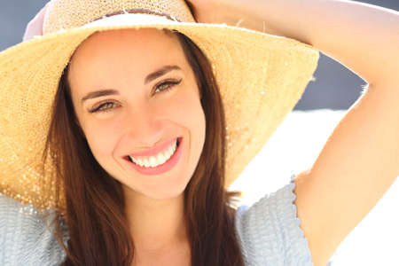 Front view portrait of a happy woman smiling at camera on the beachの写真素材