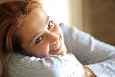 Portait of a happy woman smiling and relaxing looking at camera at homeの写真素材