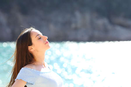 Woman relaxing on the beach breathing fresh air on summer vacationの写真素材