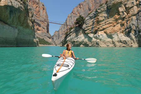 Woman on kayak relaxing looking at side in a lake on summer vacationの写真素材