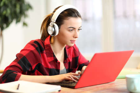 Concentrated student e-learning with laptop and headphones at homeの写真素材