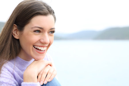 Happy woman smiling with white teeth contemplating views in natureの写真素材
