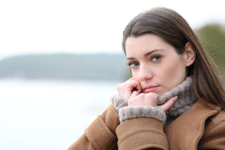 Portrait of a serious woman looking at you in winter in a lakeの写真素材