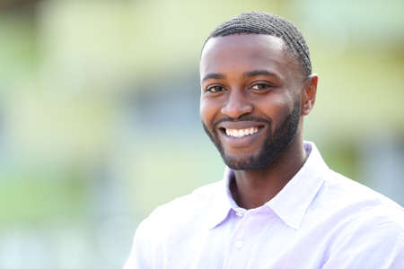 Handsome happy man with black skin and perfect smile looks at you in the streetの写真素材