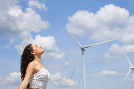 Profile of a woman breathing fresh air in a wind farmの写真素材