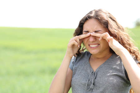 Stressed woman scratching eyes in a wheat fieldの写真素材
