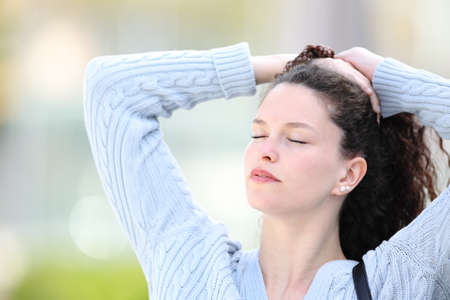 Woman standing in the street doing ponytailの写真素材