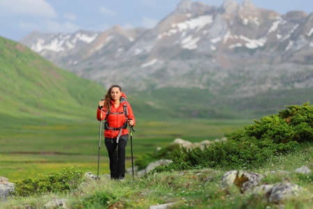 Front view portrait of a hiker walking in a green high mountainの写真素材